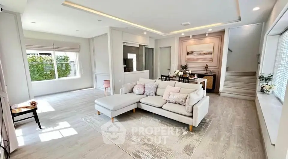 Spacious and elegantly designed living room with modern decor and ample natural light.