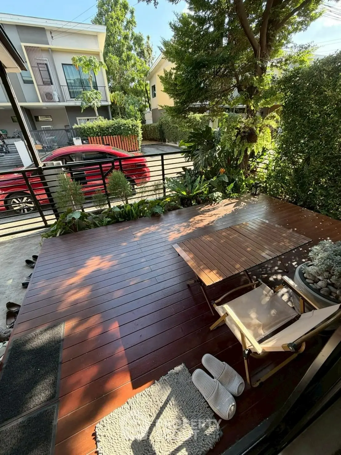 Charming wooden deck with lush greenery, perfect for relaxation and outdoor enjoyment.