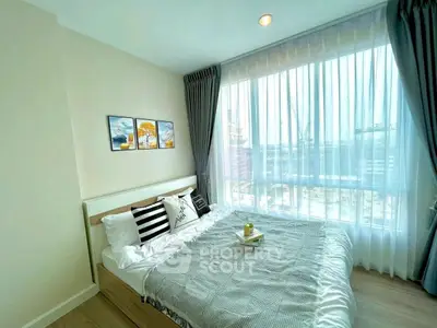 Bright and cozy bedroom with large window and stylish decor in modern apartment.