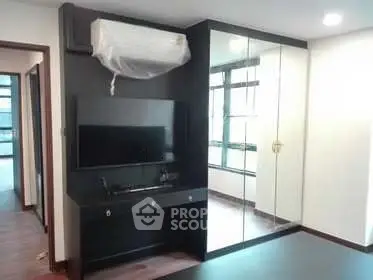 Modern living room with sleek black TV unit and mirrored wardrobe