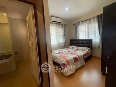 Cozy bedroom with ensuite bathroom, featuring modern decor and ample natural light.