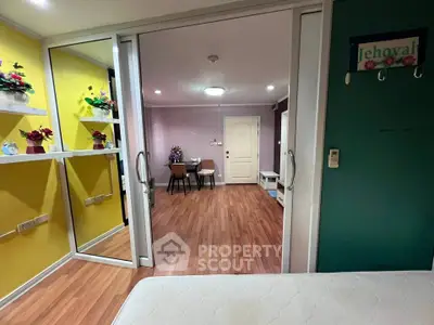 Spacious living area with vibrant decor and sliding glass doors in modern apartment.