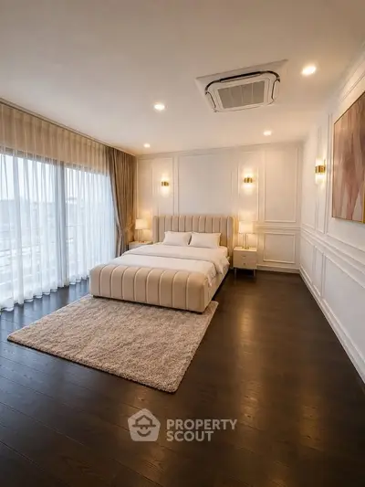 Luxurious bedroom with elegant decor and large windows offering natural light.