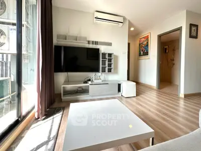 Modern living room with sleek TV unit and air conditioning, featuring wooden flooring and natural light.
