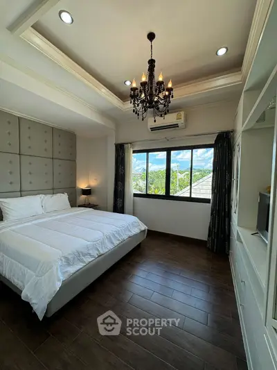 Luxurious bedroom with elegant chandelier and scenic window view