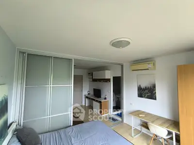 Modern studio apartment with sliding doors and compact workspace