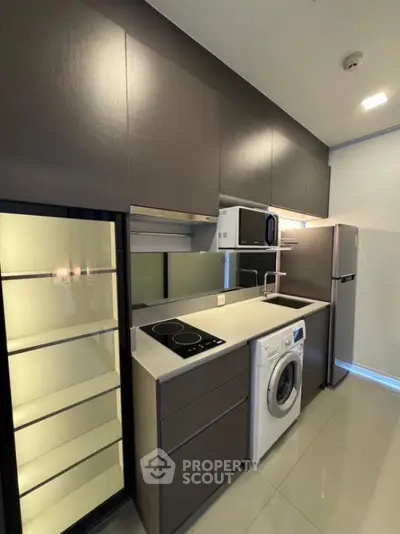Modern kitchen with sleek cabinets, washing machine, and built-in appliances