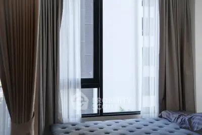 Cozy bedroom with large window and elegant curtains