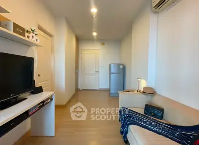 Cozy living room with modern decor and natural lighting, featuring a compact fridge and stylish furnishings.