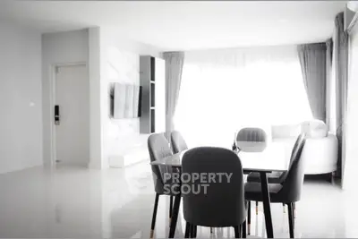 Modern dining area with sleek table and chairs in bright, open living space.