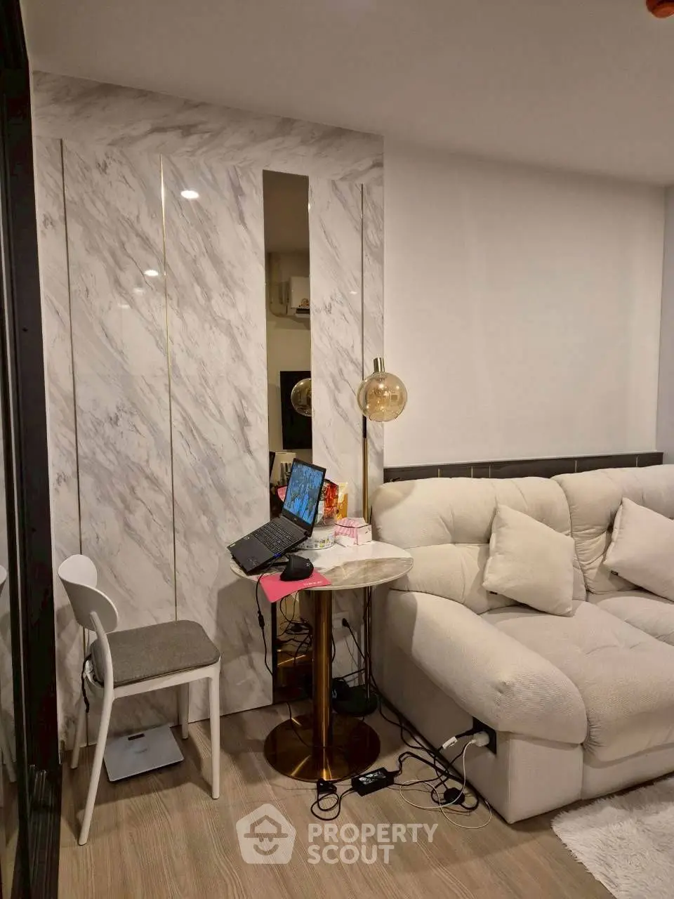 Modern living room with cozy white sofa and stylish marble accent wall