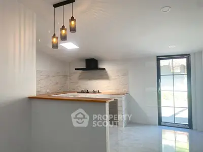Modern kitchen with open layout and stylish lighting in a bright, airy space.