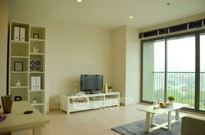 Spacious modern living room with large windows and city view, featuring elegant furniture and decor.