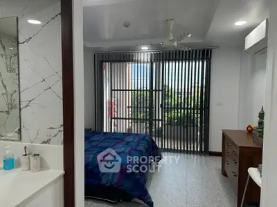 Spacious bedroom with modern decor and access to a private balcony with scenic views.