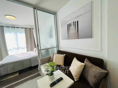 Modern studio apartment with cozy living area and bedroom separated by glass partition.