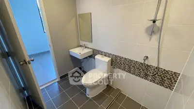 Modern bathroom with sleek design and tiled walls in a real estate property.