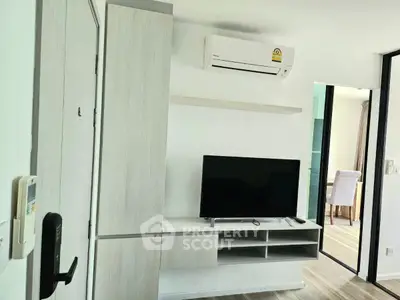 Modern living room with sleek TV unit and air conditioning in a stylish apartment.