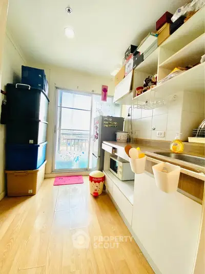 Bright kitchen with wooden flooring and modern appliances, featuring ample storage and natural light.