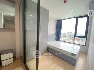 Modern bedroom with large window and city view in high-rise apartment