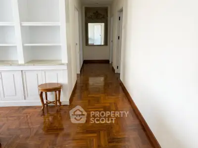 Spacious hallway with elegant wooden flooring and built-in shelving, perfect for modern living.