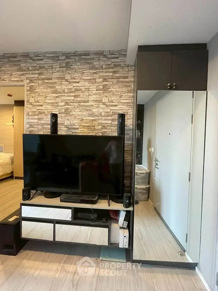 Modern living room with stylish stone accent wall and sleek entertainment center.