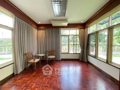 Spacious room with parquet flooring and large windows overlooking garden