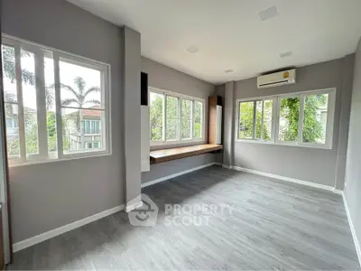 Spacious empty room with large windows and air conditioning, perfect for customization.