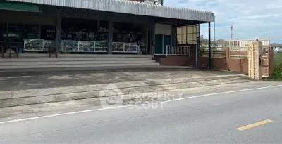 Commercial property with spacious entrance and ample parking space on a sunny day.