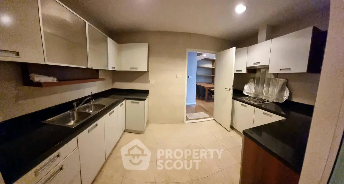Spacious kitchen with modern cabinetry and dual sinks, perfect for culinary enthusiasts.