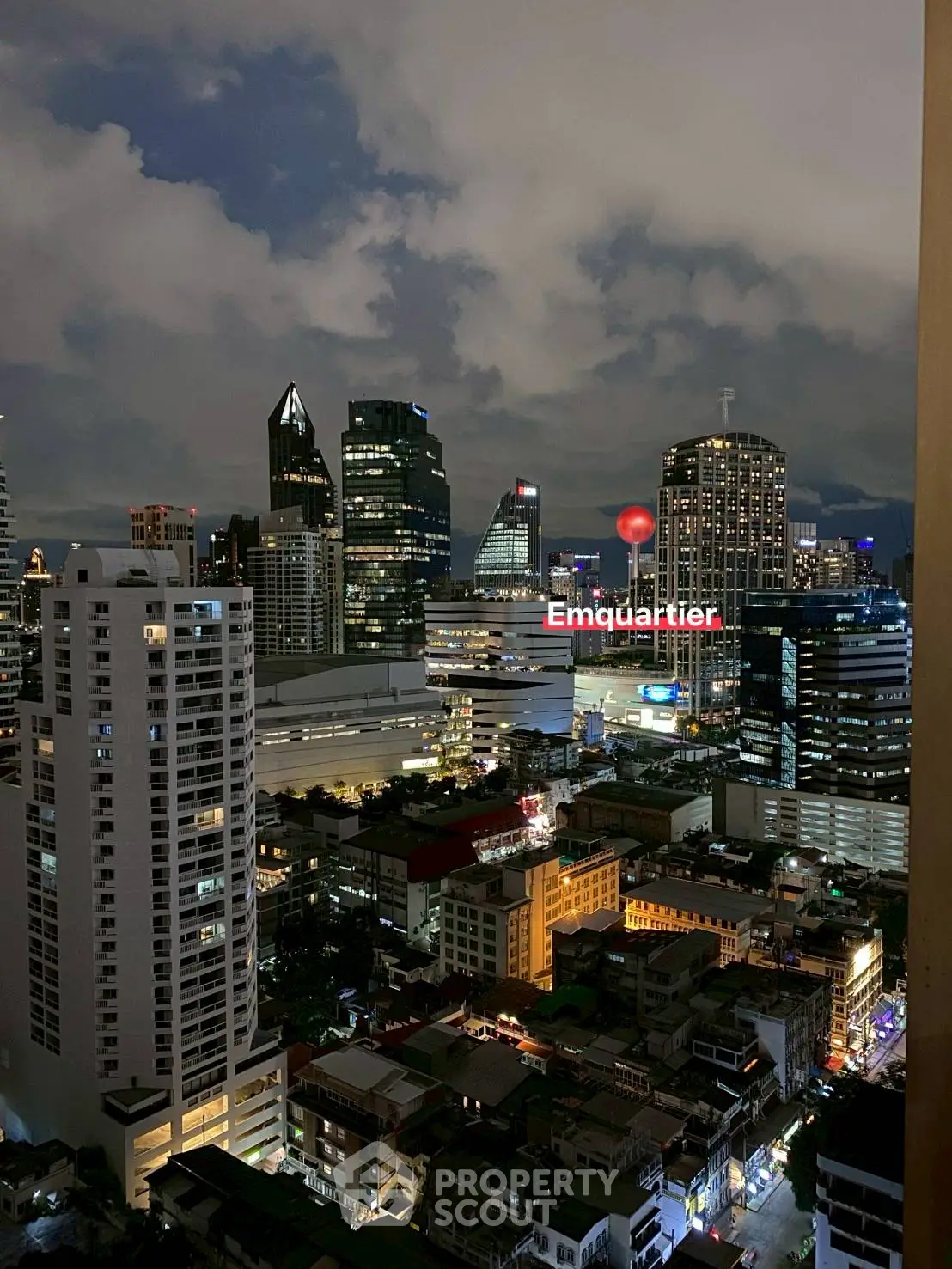 Stunning cityscape view of illuminated skyscrapers at night with Emquartier prominently visible.