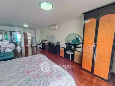 Spacious bedroom with elegant wooden flooring and ample storage space