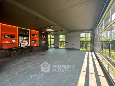 Spacious modern room with large windows and sleek design, perfect for versatile use.