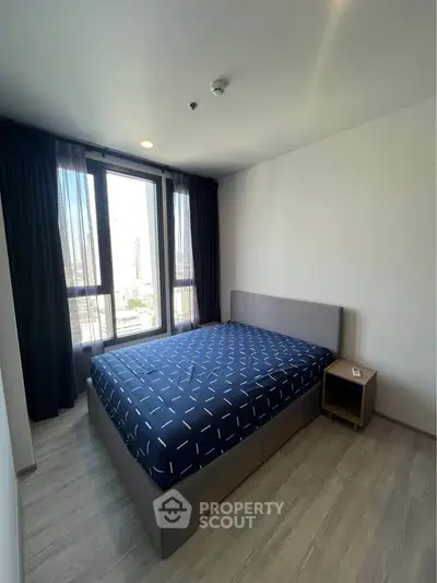 Modern bedroom with large window and stylish decor in urban apartment