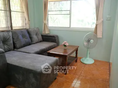 Cozy living room with plush gray sofa and wooden coffee table, perfect for relaxation.