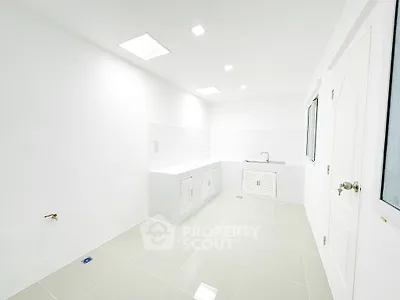 Spacious white kitchen with modern fixtures and ample storage space