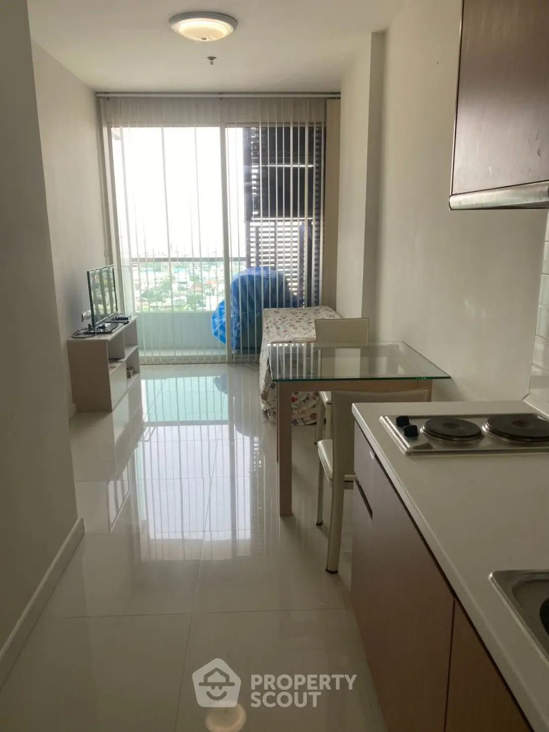 Modern studio apartment with open layout and city view, featuring sleek kitchen and cozy living area.