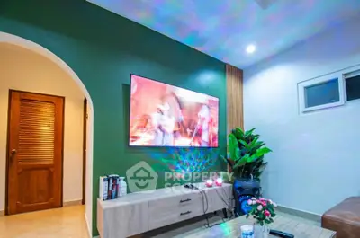 Modern living room with stylish decor and large wall-mounted TV