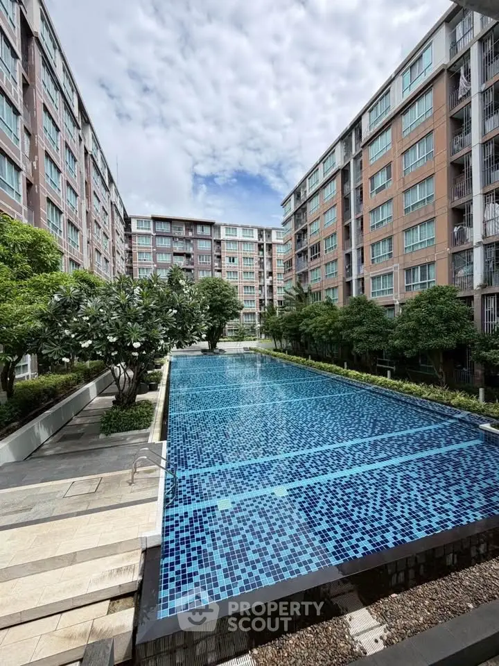 Luxurious apartment complex with stunning outdoor pool and lush greenery.