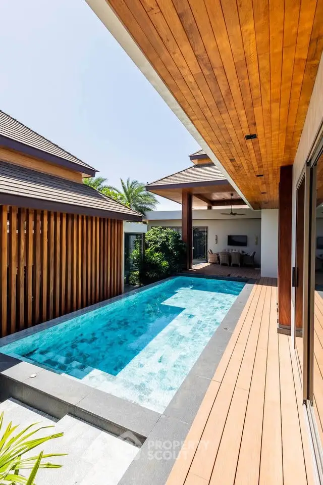 Luxurious modern home with private pool and wooden deck, perfect for relaxation and entertainment.