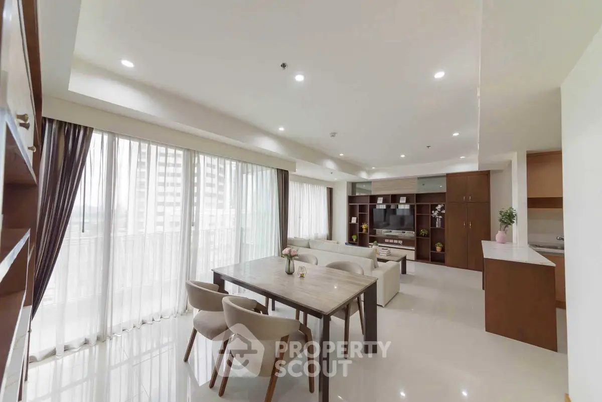 Spacious modern living room with elegant dining area and large windows in a luxury apartment.