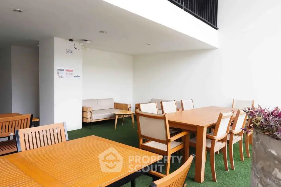 Spacious outdoor seating area with modern wooden furniture in a residential building.