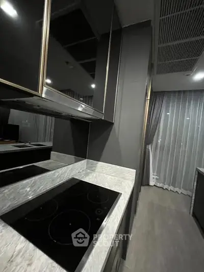 Modern kitchen with sleek black cabinets and electric stove