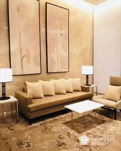 Elegant living room with plush beige sofa set, modern art, and chic table lamps, exuding luxury and comfort in a high-end property.