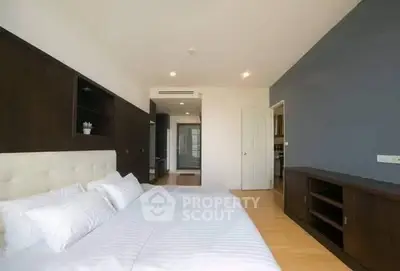 Spacious modern bedroom with elegant wooden furnishings and natural light.