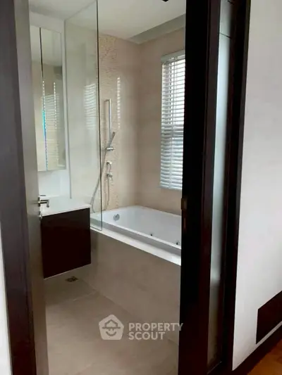 Modern bathroom with sleek design and bathtub in contemporary apartment.