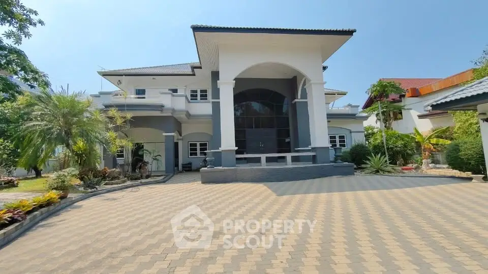 Stunning luxury home with grand entrance and spacious driveway in a serene neighborhood.