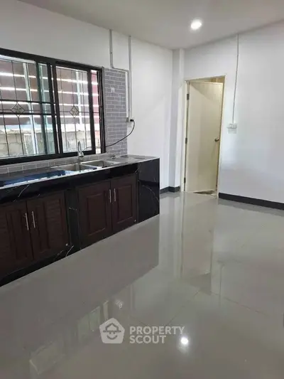 Modern kitchen with sleek countertops and ample natural light, perfect for culinary enthusiasts.
