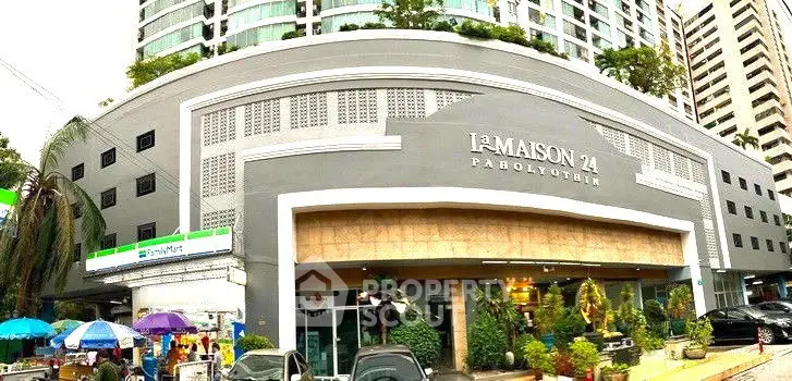 Modern urban building exterior with commercial spaces and lush greenery.