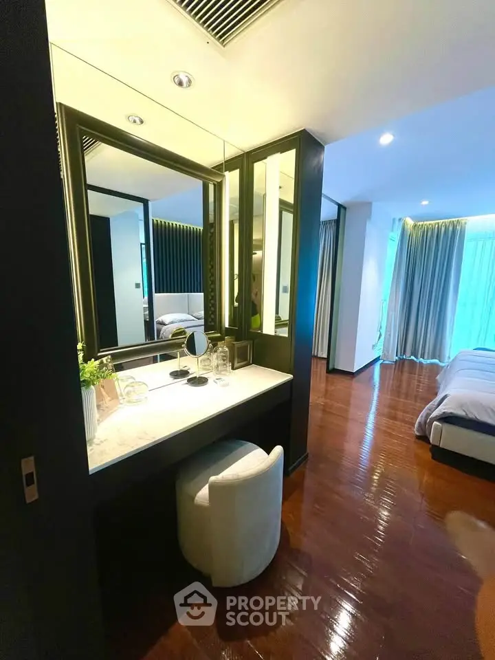 Luxurious bedroom with elegant vanity and floor-to-ceiling windows in modern apartment.