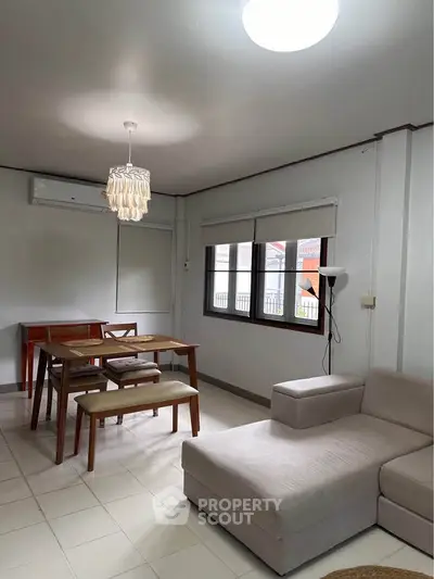 Spacious living room with modern furniture and natural light, perfect for relaxation and entertaining.